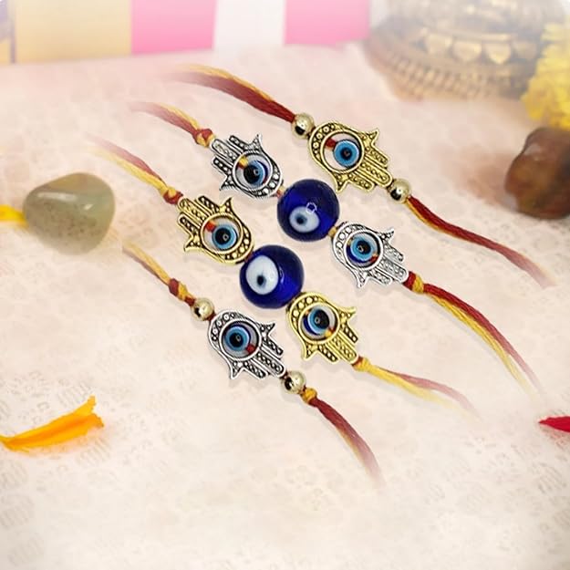 Set of three decorative necklaces with eye-shaped beads and Hamsa hand charms on a soft surface.